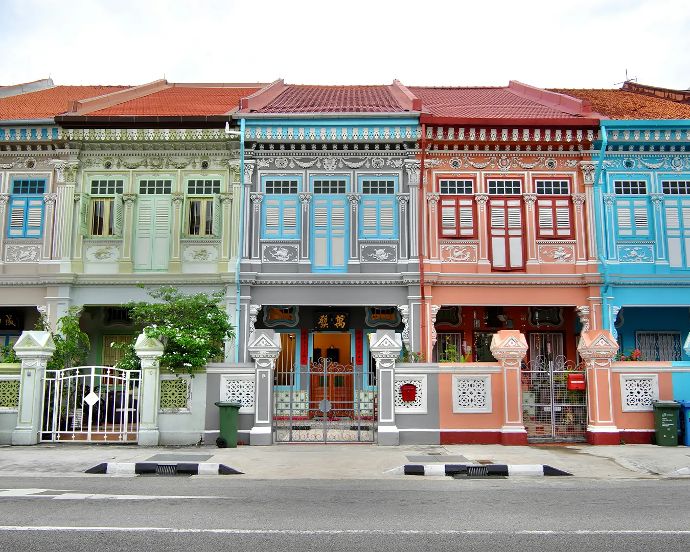 A row of beautifully restored Peranakan heritage shophouses along Katong Street in Singapore, showcasing pastel colours, intricate ceramic tiles, and ornate wooden shutters that reflect the rich cultural history of the Peranakan community.