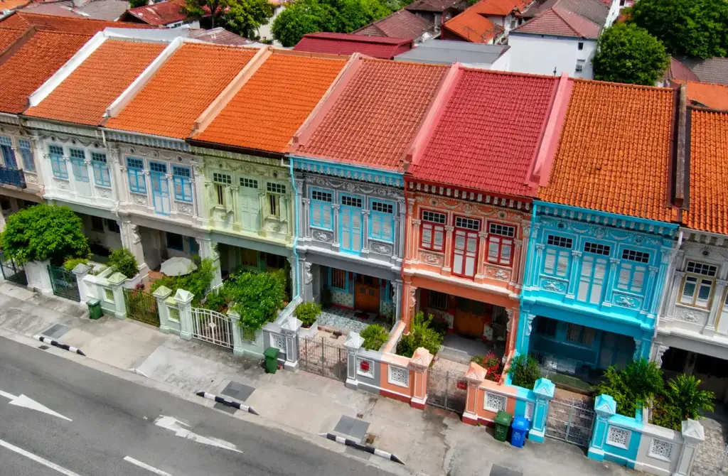 A row of beautifully restored Peranakan heritage shophouses along Katong Street in Singapore, showcasing pastel colours, intricate ceramic tiles, and ornate wooden shutters that reflect the rich cultural history of the Peranakan community.