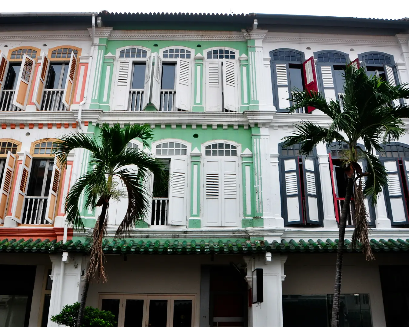 Iconic Peranakan shophouses lining Katong streets, decorated with vibrant tiles, floral motifs, and classic colonial architectural details that capture the unique blend of Chinese and Malay cultural influences.