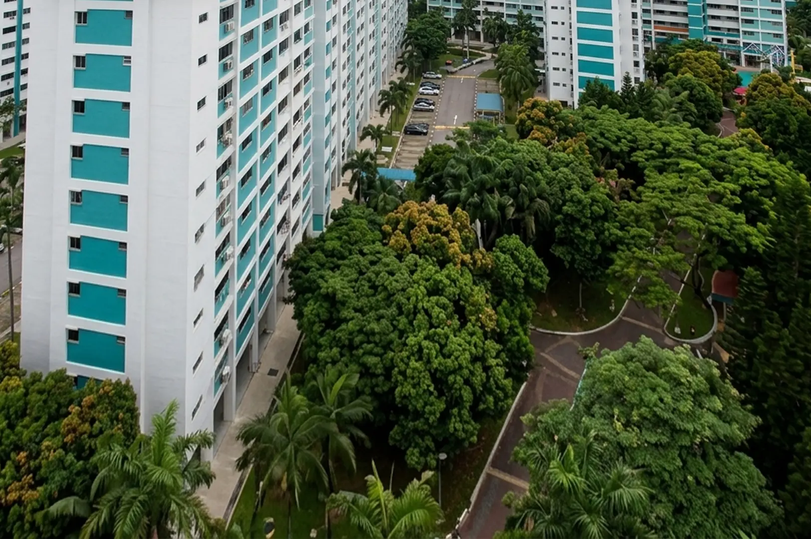 Aerial view of blue and white HDB apartment blocks surrounded by lush greenery in West Coast Road, Clementi, Singapore