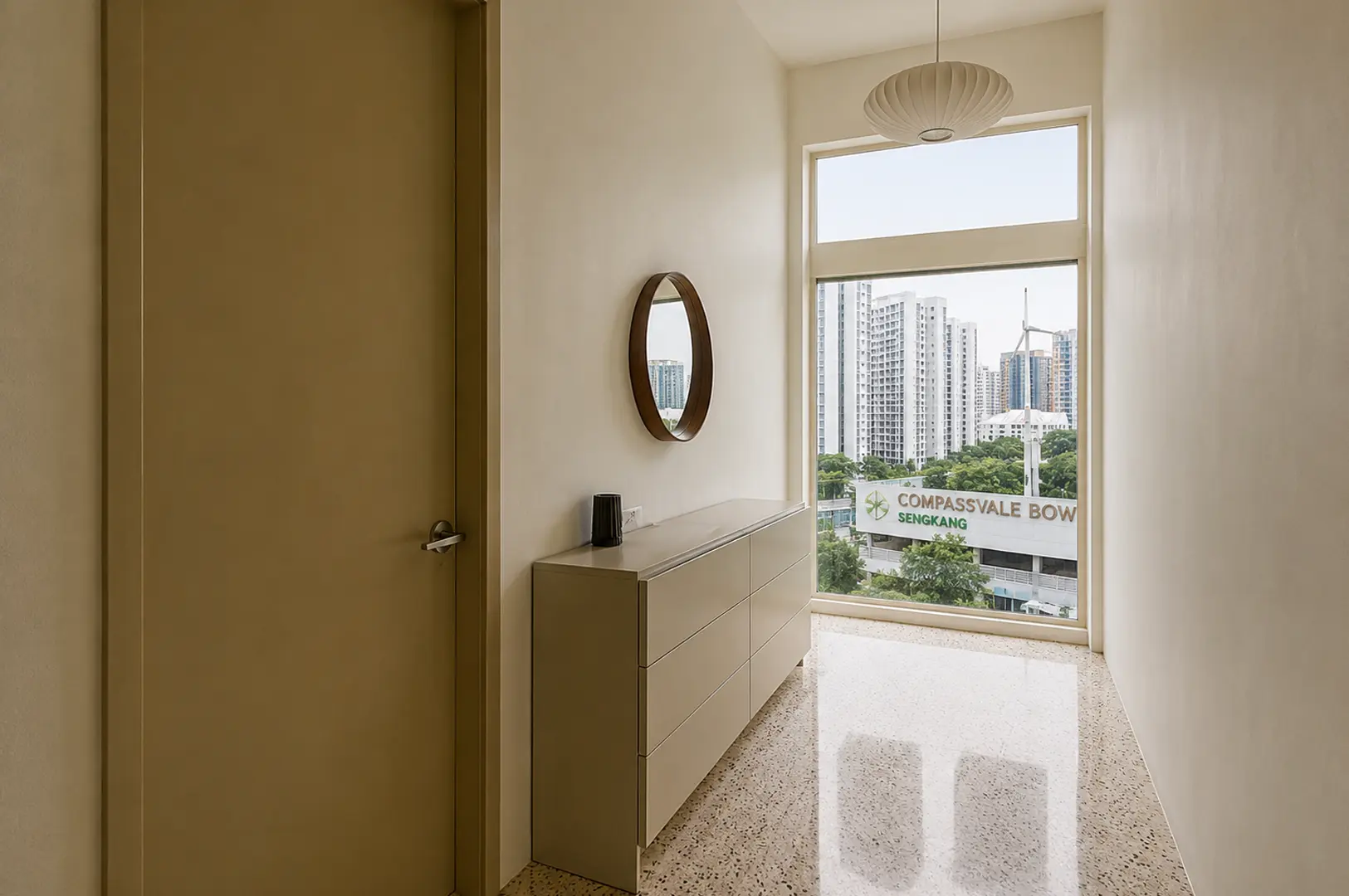 Minimalist hallway with polished terrazzo flooring leading to a large window overlooking Sengkang, Singapore