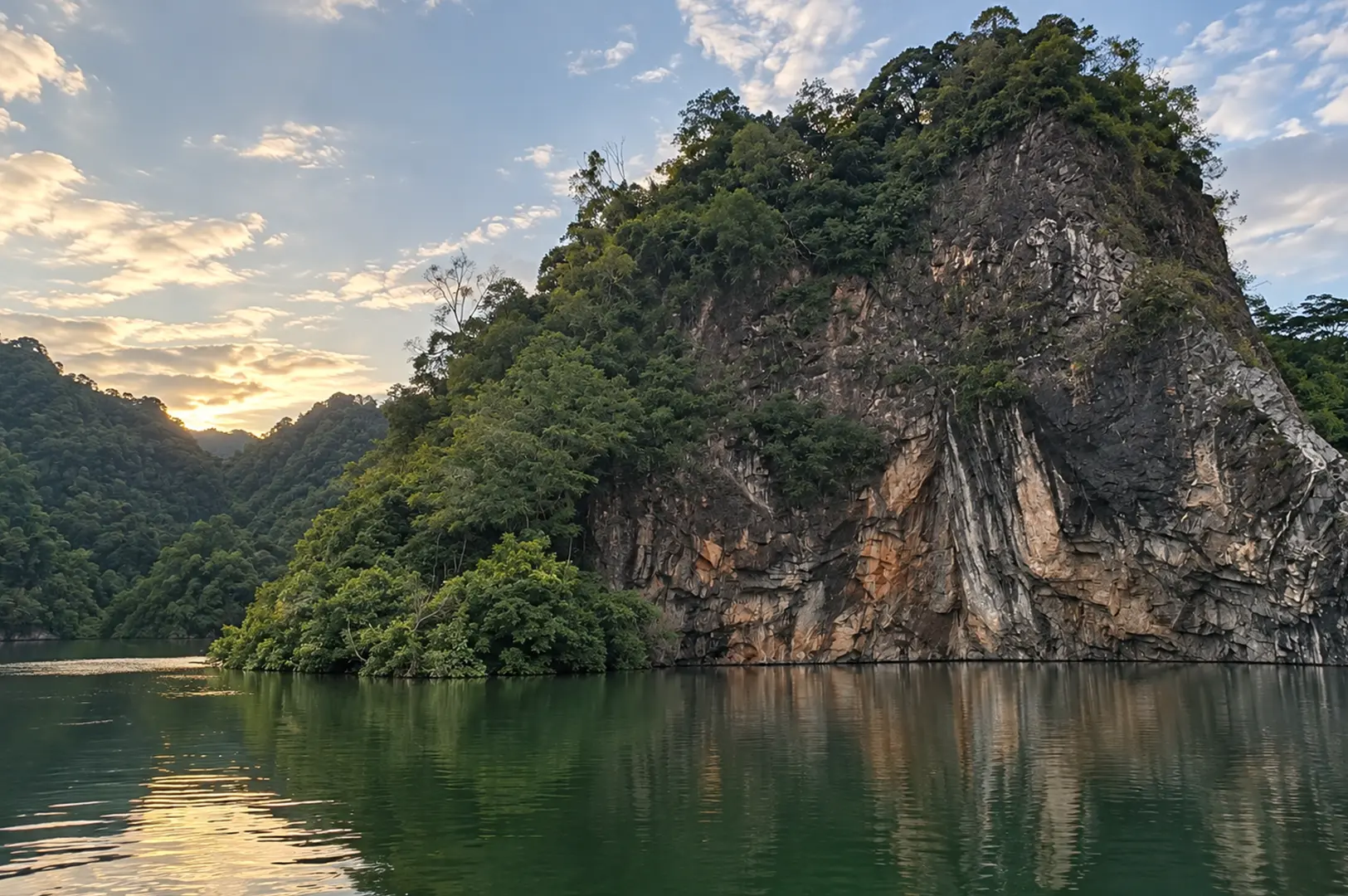 A dramatic granite cliff surrounded by lush greenery rises above a calm lake, reflecting Bukit Batok’s natural landscape and quarry heritage.