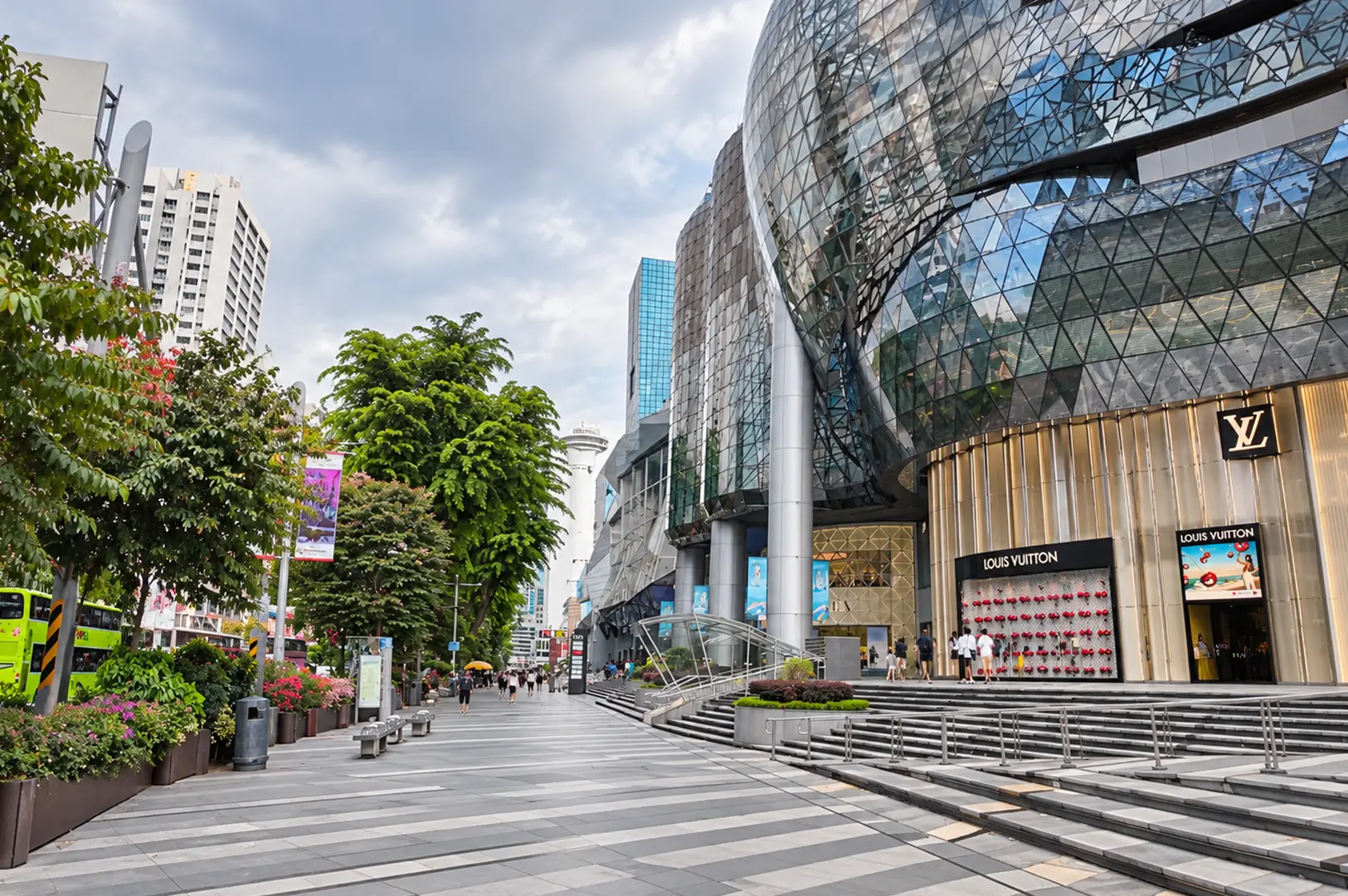 Orchard shopping district with glass-fronted ION Orchard and a tree-lined pedestrian walkway.